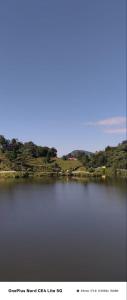 a large body of water with trees in the background at Pranavan Homestay in Mirik