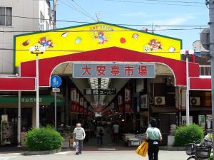 a building with a sign in the middle of a street at Kobe Youth Hostel in Kobe