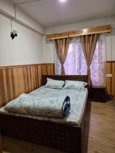 a bedroom with a large bed in front of a window at Pranavan Homestay in Mirik