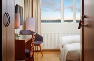 a hotel room with a desk and a window at Hérað - Berjaya Iceland Hotels in Egilsstaðir