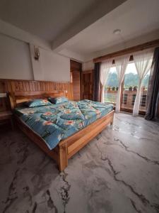 a bedroom with a large bed in front of a window at Pranavan Homestay in Mirik