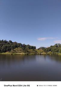 a large body of water with trees in the background at Pranavan Homestay in Mirik