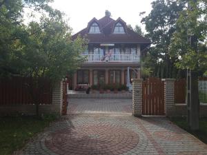 ein großes Haus mit einem Zaun und einer Veranda in der Unterkunft Dessewffy Guesthouse in Zamárdi