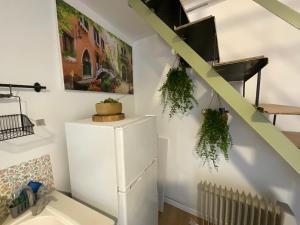 ein Zimmer mit einem weißen Kühlschrank und einer Treppe in der Unterkunft Green gallery in Haifa