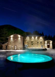 a large swimming pool in front of a building at night at Monastero Sant'Alberico Relais in Balze