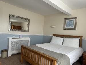 a bedroom with a large bed with a mirror at The Lindum in Hastings