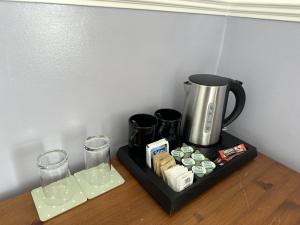 a tray with a coffee maker and glasses on a table at The Lindum in Hastings