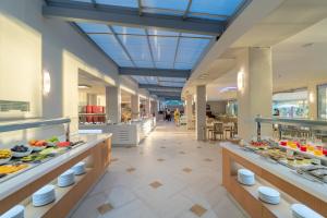 a cafeteria with a buffet line with food on display at Porto Galini Seaside Resort & Spa in Nikiana