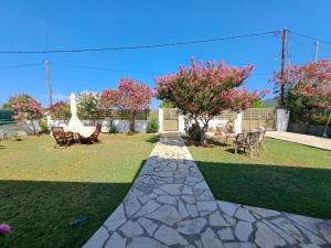 a garden with a stone walkway and a table and chairs at Ektor Villa in Agios Georgios