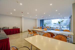 a restaurant with tables and chairs and a large window at Banquesta Suites in Noida