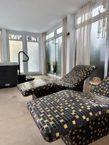 a living room with two chairs and a bed at Al-Dom Apartamenty, SUN w Welle z dostępem do sauny i jacuzzi in Grzybowo +18 photos