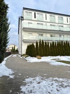 a building with christmas trees in front of it at Al-Dom Apartamenty, SUN w Welle z dostępem do sauny i jacuzzi in Grzybowo