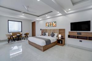 a bedroom with a large bed and a flat screen tv at Banquesta Suites in Noida