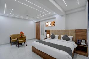 a bedroom with a large bed and a desk at Banquesta Suites in Noida +42 photos