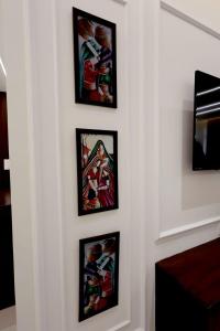a group of framed paintings on a wall at Supremo Home Stays in Agra