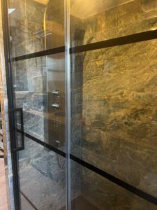 a shower in a bathroom with a stone wall at My cosy space in Spa