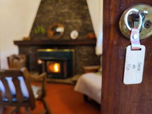a door latch with a key in a room with a fireplace at Casa do Rio, Natureza - Nova Gestão in Melgaço