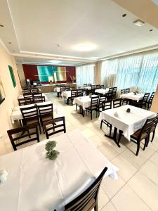 a restaurant with tables and chairs with white tables at Kornilios Istron Hotel in Giannitsa