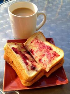 Zwei Scheiben Brot auf einem Teller neben einer Tasse Kaffee in der Unterkunft Jee Ri Haveli in Jodhpur