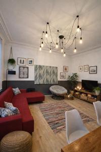 a living room with a red couch and a table at Duplex dans le centre d'Heusy in Verviers