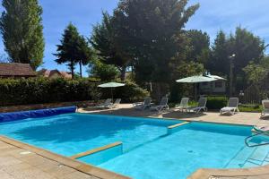 a large blue swimming pool with chairs and umbrellas at Camping le Relais du Léman in Messery