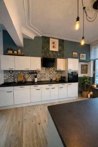 a kitchen with white cabinets and a counter top at Duplex dans le centre d'Heusy in Verviers