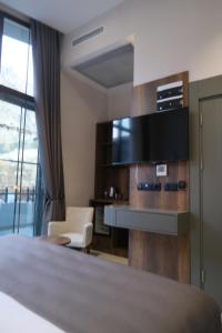 a hotel room with a bed and a desk and a tv at 1921 justa sefa otel in Amasya