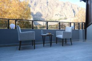 two chairs and a table on a balcony with a view at 1921 justa sefa otel in Amasya