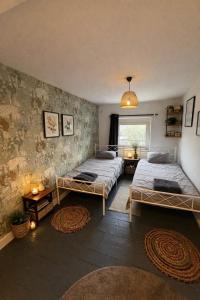 a bedroom with two beds and a window at Duplex dans le centre d'Heusy in Verviers