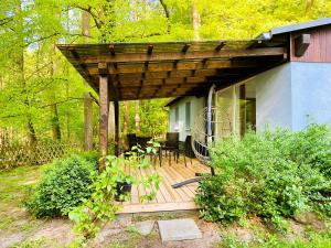 a wooden deck with a table and chairs on a house at Waldschenke Stendenitz Übernachten im Wald am See in Neuruppin