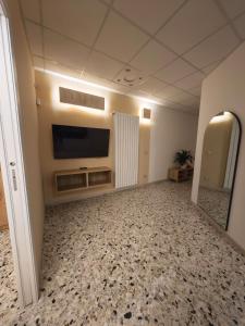 a large room with a flat screen tv on a wall at Arlecchino Rooms in Santa Maria Codifiume