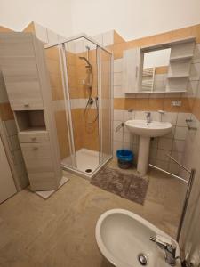 a bathroom with a glass shower and a sink at Arlecchino Rooms in Santa Maria Codifiume