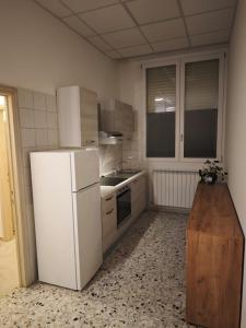 a kitchen with a white refrigerator and a stove at Arlecchino Rooms in Santa Maria Codifiume