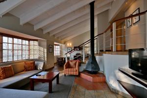 a living room with a couch and a fireplace at Glenburn Lodge & Spa in Muldersdrift