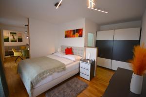a bedroom with a bed and a desk and a room at Ferienwohnungen Neubauer in Kaltenberg