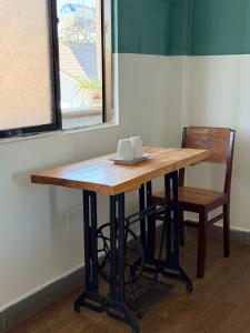 a wooden table with a chair next to a window at Thái Lâm Hotel in Da Lat +20 photos