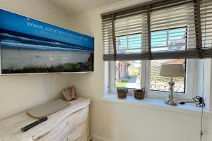 a living room with a tv and a window at Engels Hüs in Tinnum