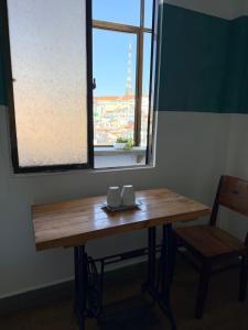 a wooden table with two mugs on it next to a window at Thái Lâm Hotel in Da Lat