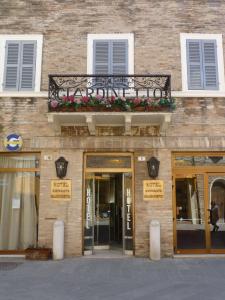 ein Gebäude mit einem Balkon mit Blumen darauf in der Unterkunft Hotel Giardinetto in Loreto