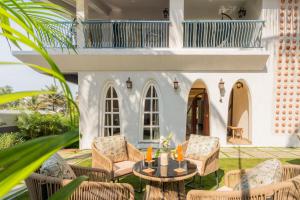 a patio with chairs and a table in front of a house at Casa Mandala by ELIVAAS in Candolim