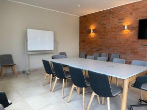 a conference room with a table and chairs and a whiteboard at ZenKai Mamelles Hotel in Dakar