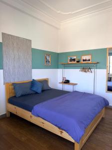 a bedroom with a large bed with blue sheets at Thái Lâm Hotel in Da Lat