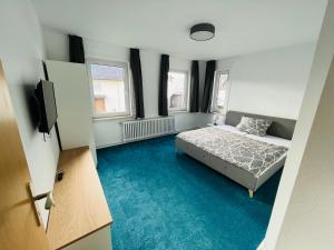 a bedroom with a bed and a tv in it at Ferienwohnung am Eberbach in Stadtoldendorf