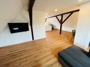 a living room with a couch and a flat screen tv at Ferienwohnung am Eberbach in Stadtoldendorf