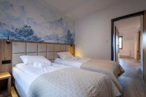 two beds sitting next to each other in a bedroom at Apartamenty Beski in Szczyrk