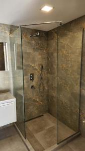 a shower with a glass door in a bathroom at Harmony house in Bakuriani
