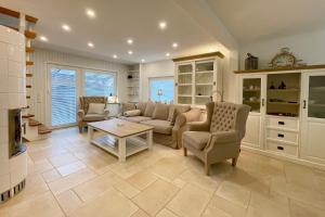 a living room with a couch and chairs and a table at Ferienhaus Eibenweg 6 in Tinnum