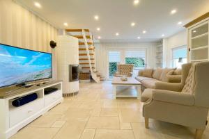 a living room with a large television and a couch at Ferienhaus Eibenweg 6 in Tinnum