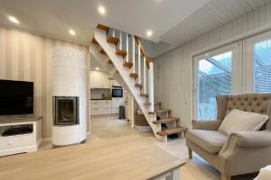 a living room with a spiral staircase and a television at Ferienhaus Eibenweg 6 in Tinnum