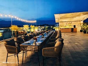 a row of tables and chairs on a patio at night at Hotel Central Palace in Dehradun